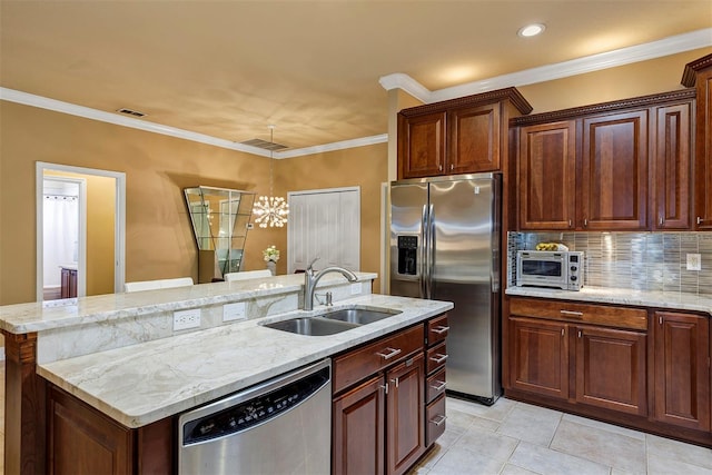 kitchen with sink, a notable chandelier, crown molding, a center island with sink, and appliances with stainless steel finishes