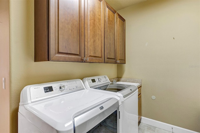 clothes washing area featuring cabinets and independent washer and dryer