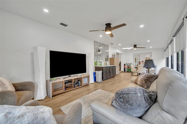 living room featuring ceiling fan and light hardwood / wood-style flooring