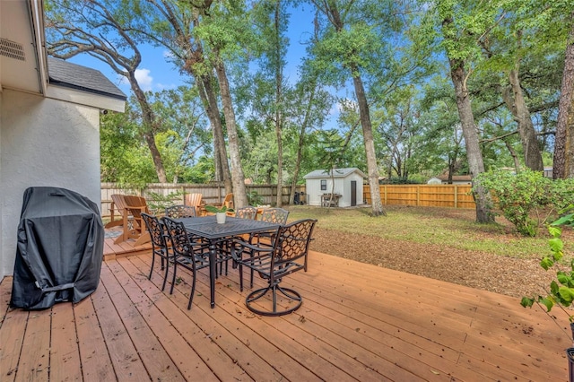 wooden deck featuring area for grilling and a storage shed