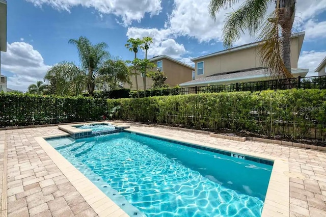 view of swimming pool with a fenced backyard, a pool with connected hot tub, and a patio area