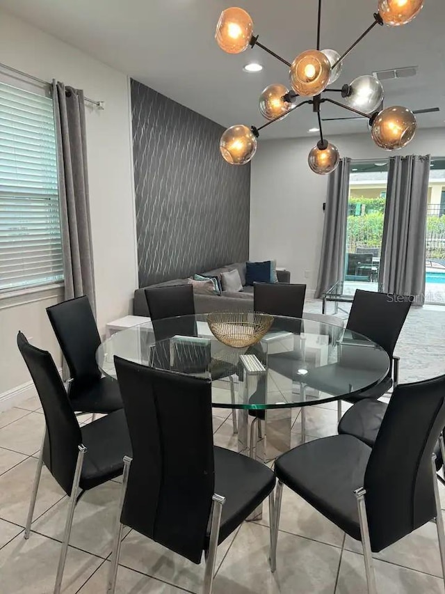 dining room featuring baseboards, visible vents, light tile patterned floors, and an accent wall