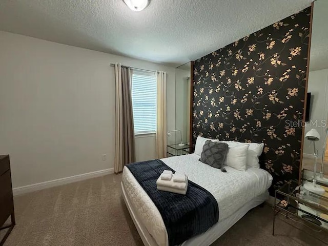 carpeted bedroom with baseboards and a textured ceiling