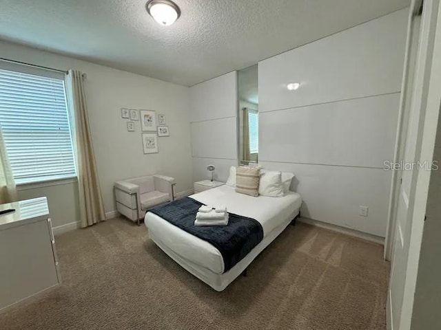 bedroom featuring light colored carpet and a textured ceiling