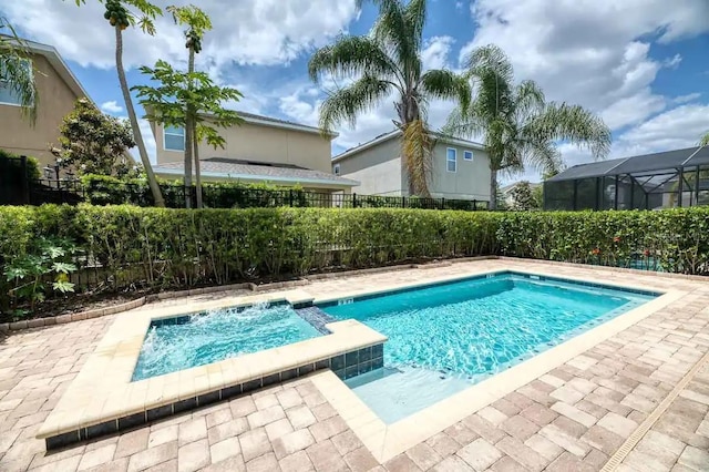 view of swimming pool with a patio, a fenced backyard, and a pool with connected hot tub