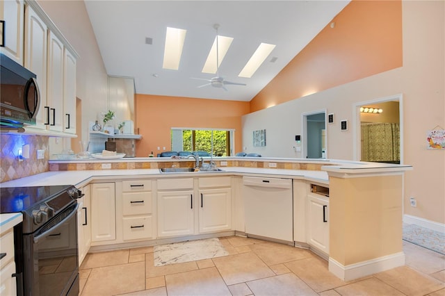 kitchen with sink, kitchen peninsula, black appliances, a skylight, and ceiling fan