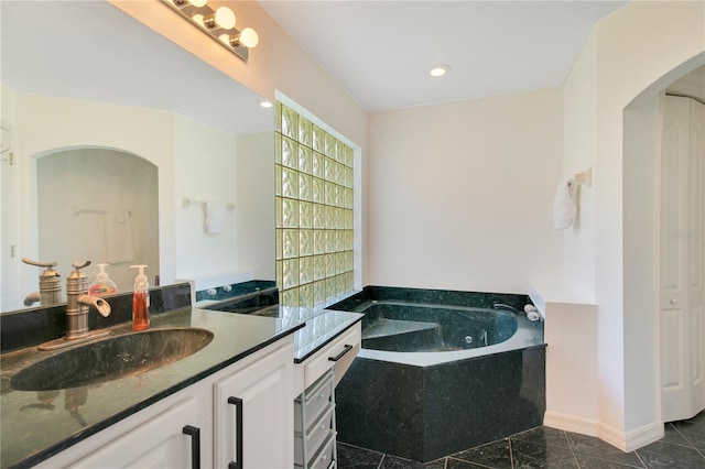 bathroom featuring vanity, a washtub, and tile patterned floors