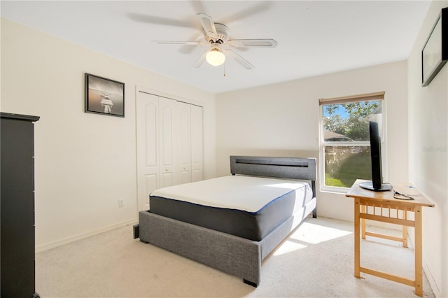 bedroom with a closet, ceiling fan, and light colored carpet