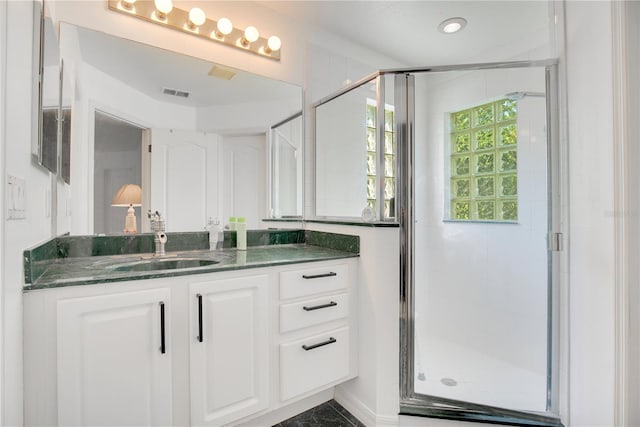 bathroom with vanity and a shower with door