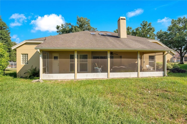 rear view of property featuring a sunroom and a lawn