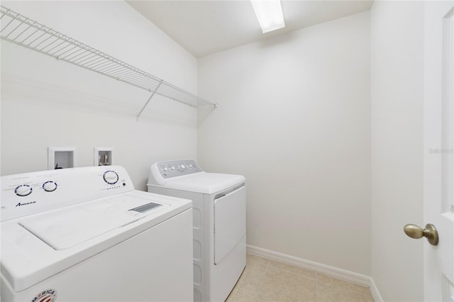 laundry room featuring washer and clothes dryer and light tile patterned floors