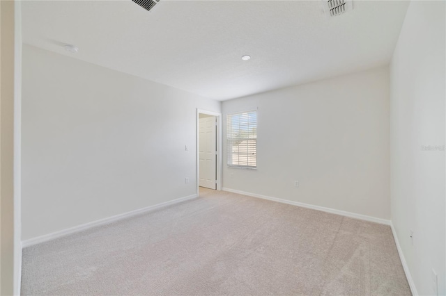 spare room featuring light colored carpet