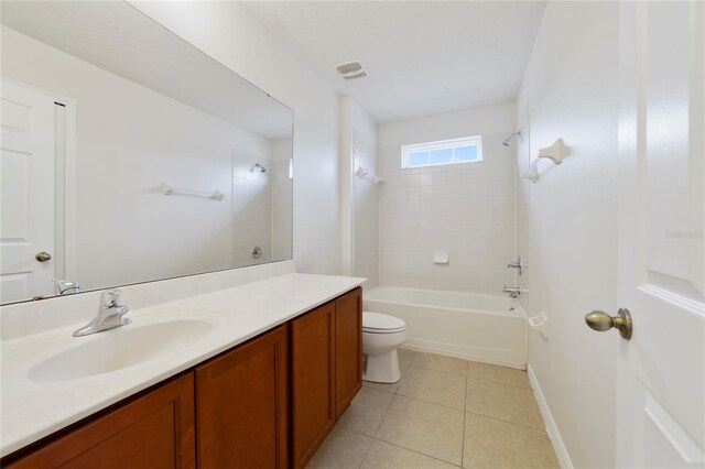 full bathroom with tile patterned floors, tiled shower / bath combo, vanity, and toilet