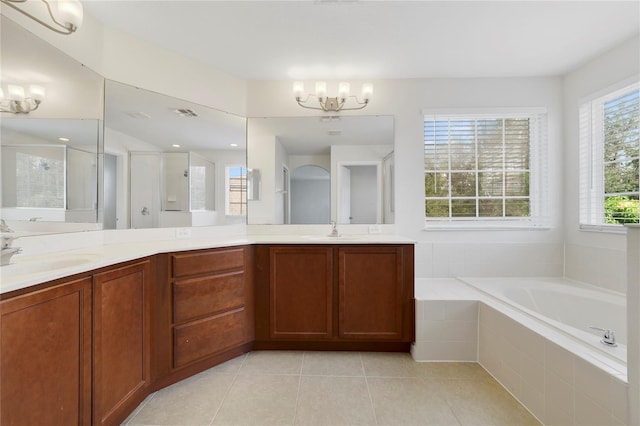 bathroom with a notable chandelier, tile patterned floors, vanity, and separate shower and tub