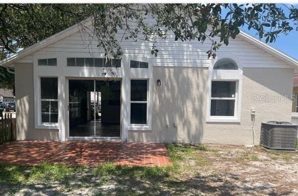 rear view of property with central AC unit and a patio