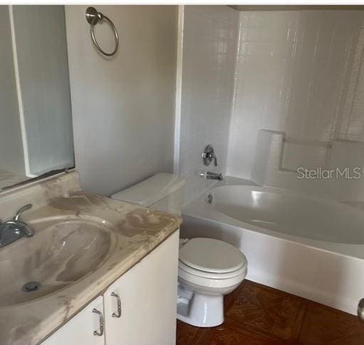 full bathroom featuring washtub / shower combination, vanity, and toilet