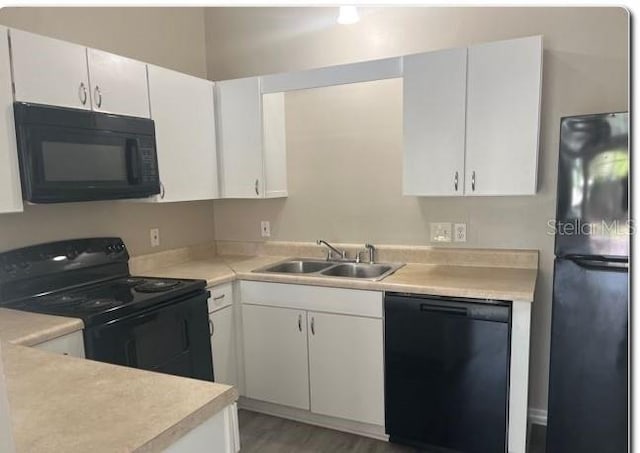 kitchen featuring black appliances, white cabinetry, sink, and wood-type flooring