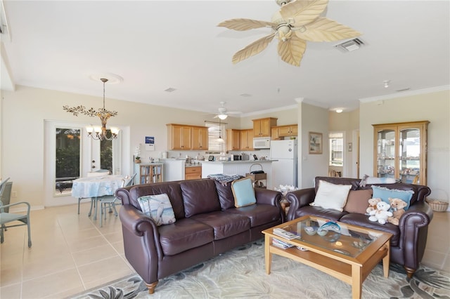 living room with ceiling fan with notable chandelier, crown molding, light tile patterned floors, and french doors