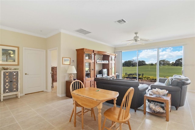 tiled dining area featuring ornamental molding and ceiling fan