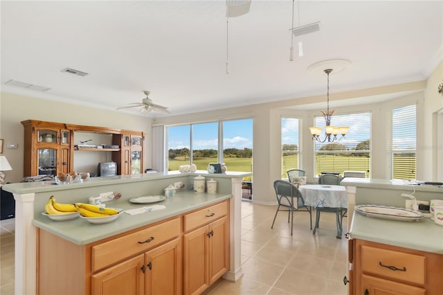 kitchen featuring ceiling fan with notable chandelier, decorative light fixtures, crown molding, and light tile patterned floors