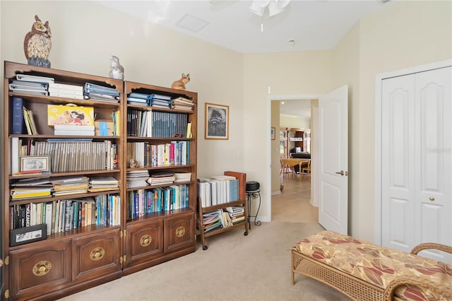 sitting room with ceiling fan and light colored carpet