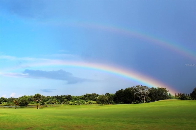view of community featuring golf course view and a yard