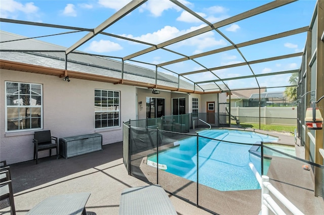 view of swimming pool featuring glass enclosure and a patio area