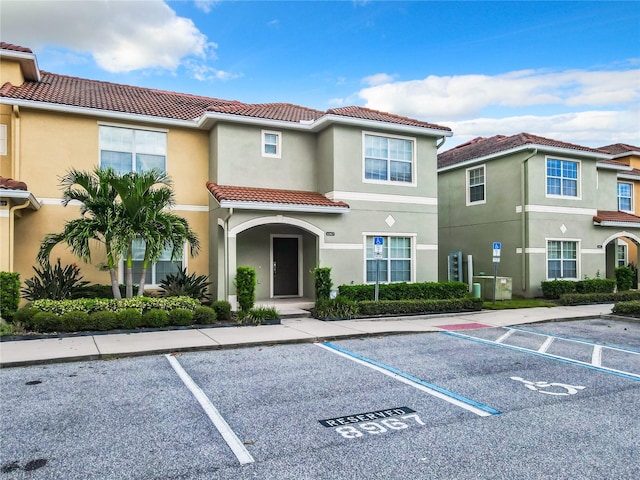 8967 California Palm Rd, Kissimmee, FL 34747 - view of front of property with uncovered parking, a tiled roof, and stucco siding