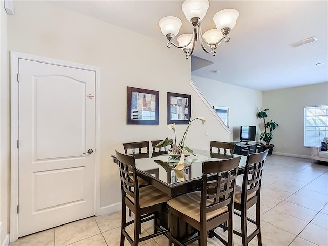 tiled dining room featuring an inviting chandelier