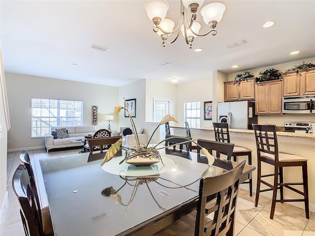 tiled dining area featuring a chandelier