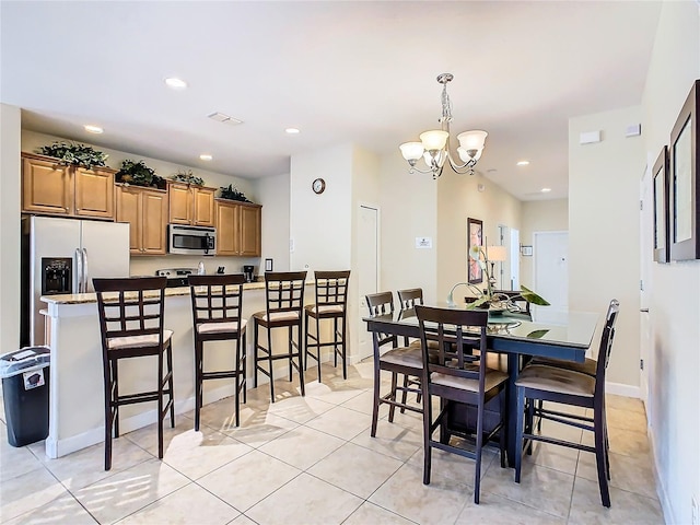 tiled dining room featuring a notable chandelier