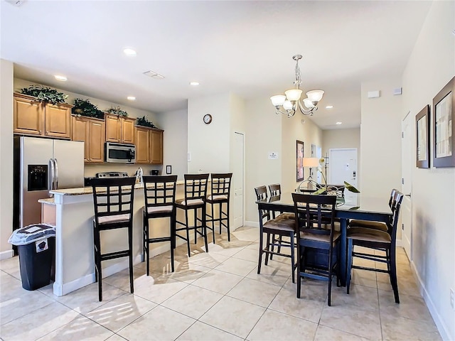 tiled dining space with a chandelier