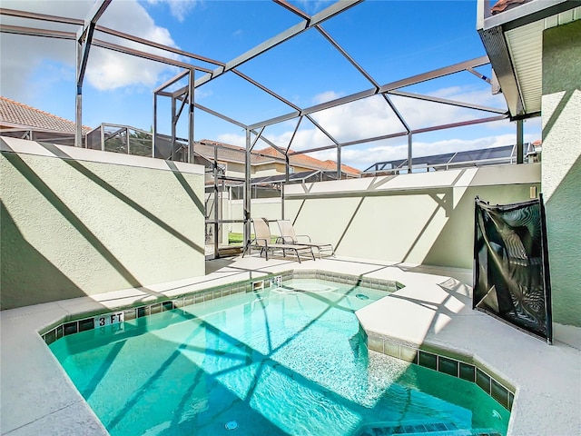 view of swimming pool featuring glass enclosure and a patio