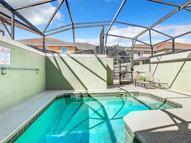 view of swimming pool with glass enclosure and a patio area