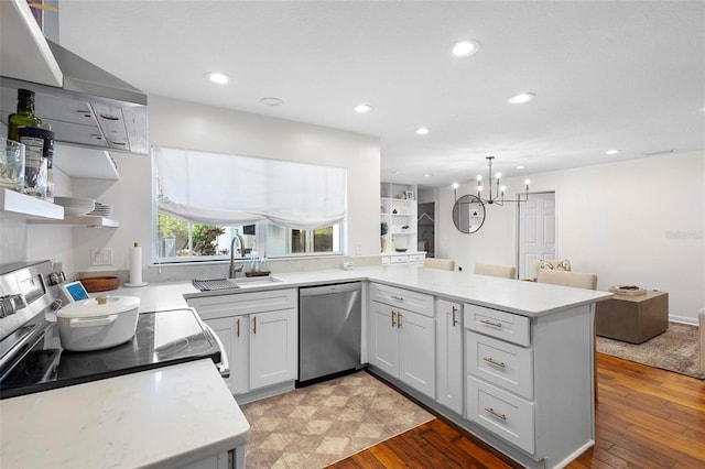 kitchen featuring kitchen peninsula, dishwasher, light hardwood / wood-style flooring, sink, and a chandelier