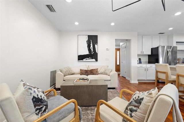 living room with a textured ceiling and hardwood / wood-style floors