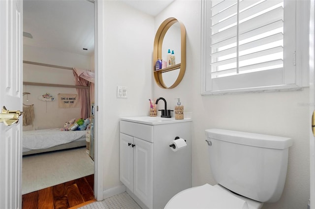 bathroom featuring wood-type flooring, vanity, and toilet