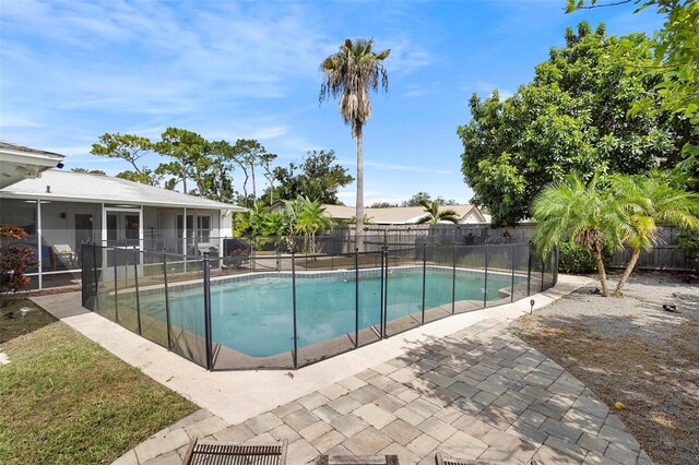 view of swimming pool featuring a sunroom and a patio area