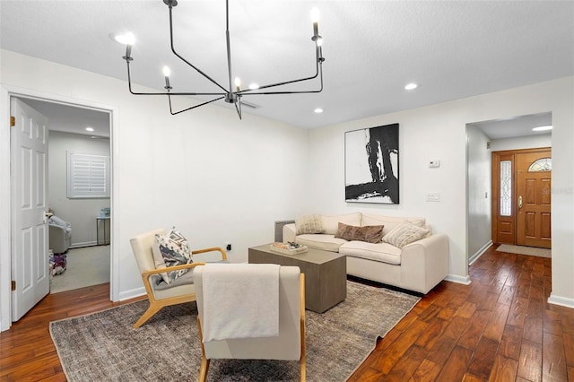 living room featuring an inviting chandelier, a textured ceiling, and dark hardwood / wood-style floors