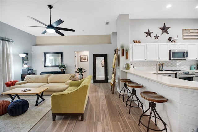 living room featuring light hardwood / wood-style floors and ceiling fan