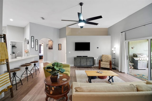 living room with ceiling fan, light hardwood / wood-style flooring, and sink