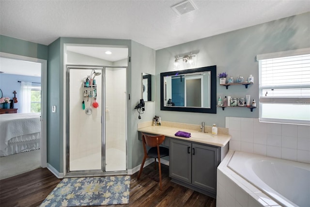 bathroom featuring hardwood / wood-style flooring, vanity, separate shower and tub, and a textured ceiling