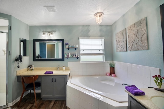 bathroom featuring separate shower and tub, vanity, wood-type flooring, and a textured ceiling