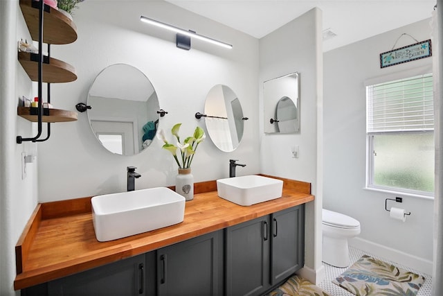 bathroom featuring tile patterned floors, vanity, and toilet