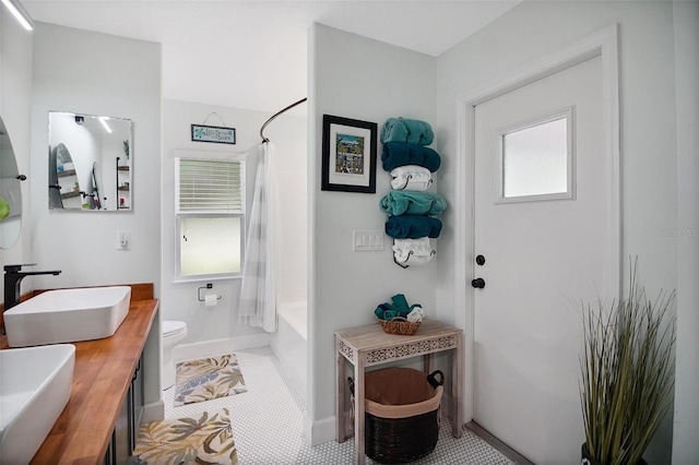 full bathroom featuring tile patterned flooring, toilet, a wealth of natural light, and shower / tub combo