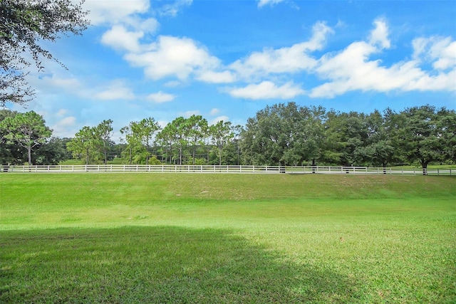 view of home's community with a rural view and a yard