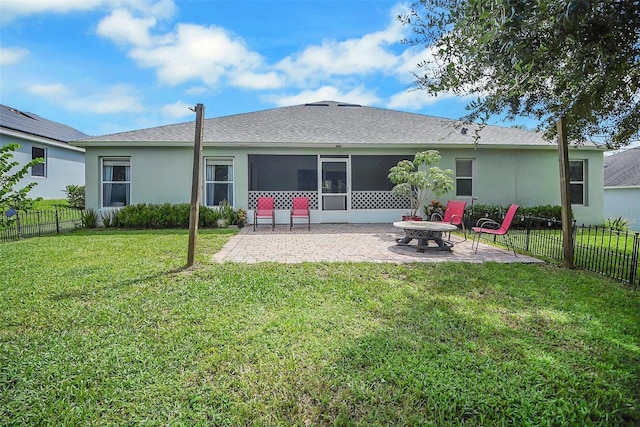 rear view of property with a sunroom, a patio area, and a yard