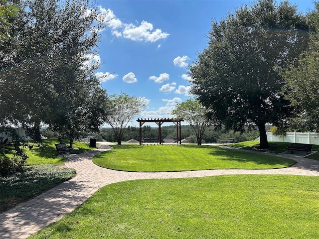 view of community with a pergola and a yard