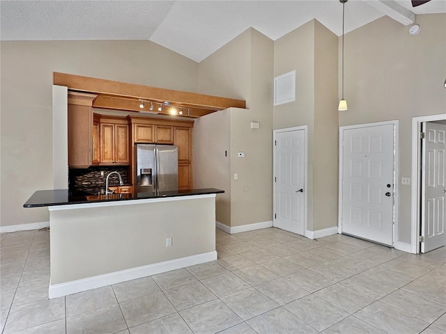 kitchen featuring decorative backsplash, light tile patterned flooring, kitchen peninsula, decorative light fixtures, and stainless steel fridge with ice dispenser