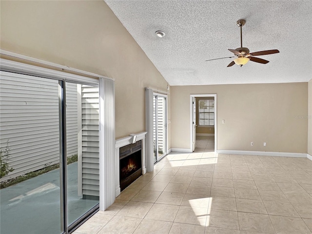 unfurnished living room with ceiling fan, a textured ceiling, light tile patterned floors, and high vaulted ceiling